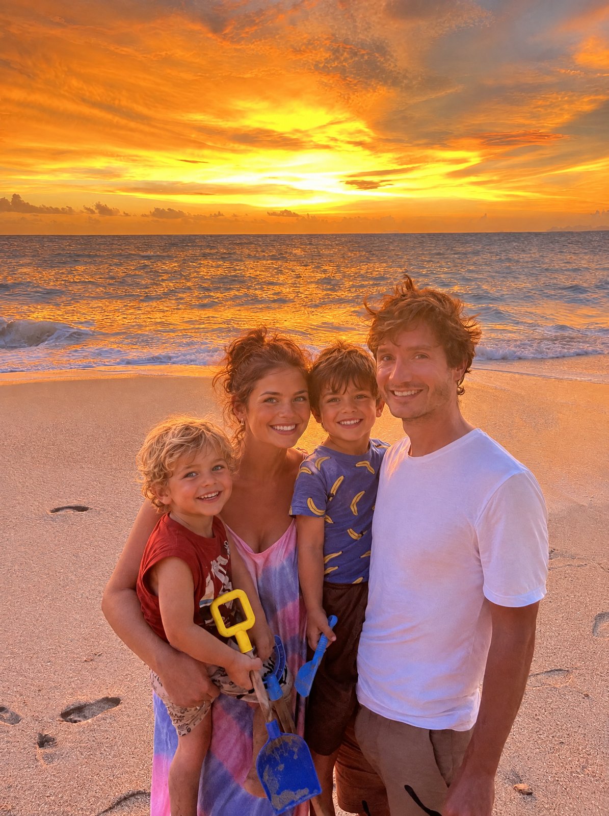 Richard with his family on a beach at sunset